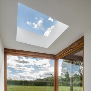 A cozy interior space featuring a skylight that illuminates the room. Large windows showcase a green landscape and cloudy sky. A patterned rug covers the floor, and plush seating is arranged along the wall.