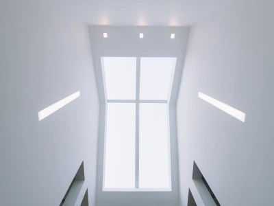Techo interior con una ventana grande que deja pasar luz natural. Paredes blancas y luces empotradas. Escalera visible en la parte inferior.