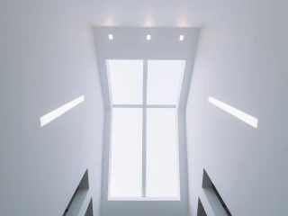Techo interior con una ventana grande que deja pasar luz natural. Paredes blancas y luces empotradas. Escalera visible en la parte inferior.